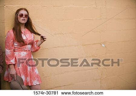Young woman stand with a hat in hand View Large Photo Image Stock Image - Young woman stand with a hat in hand. Fotosearch
