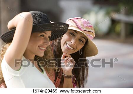 Stock Photo - Young women sitting together and smiling. Fotosearch
