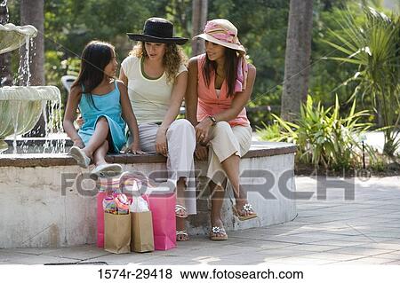 Young women with a girl sitting by water fountain View Large Photo Image Stock Photo - Young women with a girl sitting by water fountain. Fotosearch