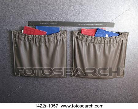 Stock Photo - Airplane seat pockets with instructions and sickness bag. Fotosearch