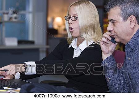 Business executives using a mobile phone and a laptop, Florida, USA View Large Photo Image Stock Image - Business executives using a mobile phone and a laptop, Florida, USA. Fotosearch