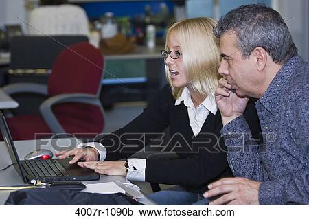 Business executives working on a laptop, Florida, USA View Large Photo Image Stock Image - Business executives working on a laptop, Florida, USA. Fotosearch