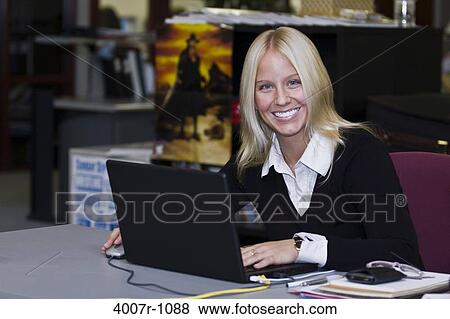 Stock Photo - Businesswoman using a laptop and smiling, Florida, USA. Fotosearch