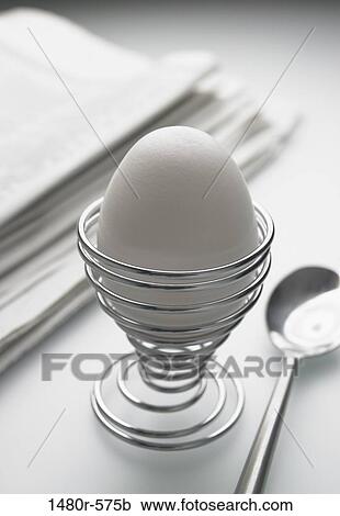 Close-up of a boiled egg in an eggcup with a newspaper View Large Photo Image Stock Image - Close-up of a boiled egg in an eggcup with a newspaper. Fotosearch