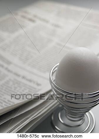 Close-up of a boiled egg in an eggcup with a newspaper View Large Photo Image Stock Image - Close-up of a boiled egg in an eggcup with a newspaper. Fotosearch