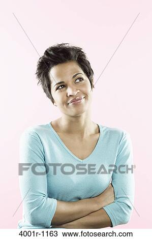 Stock Image - Close-up of a mid adult woman day dreaming. Fotosearch