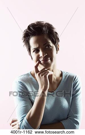 Stock Image - Close-up of a mid adult woman thinking. Fotosearch