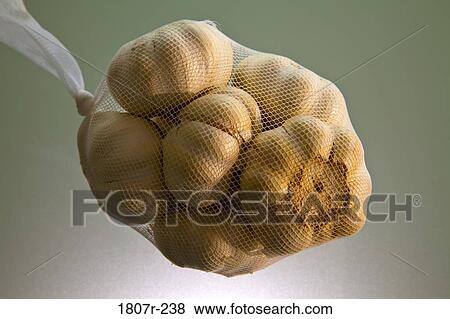 Stock Photo - Close up of garlic in net bag. Fotosearch