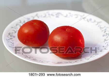 Close-up of two tomatoes on a plate View Large Photo Image Stock Image - Close-up of two tomatoes on a plate. Fotosearch