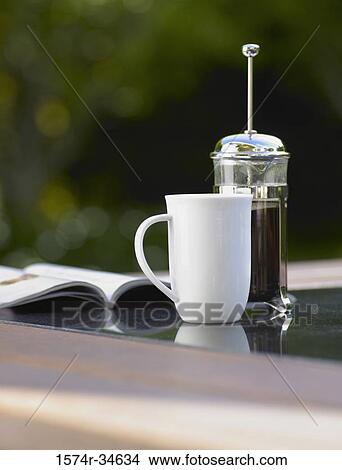 Coffee cup and a plunger on a table View Large Photo Image Picture - Coffee cup and a plunger on a table. Fotosearch
