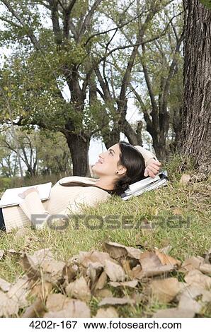 Female university student lying in the grass in campus View Large Photo Image Stock Photo - Female university student lying in the grass in campus. Fotosearch