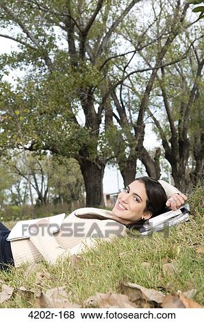 Female university student lying in the grass in campus View Large Photo Image Stock Photo - Female university student lying in the grass in campus. Fotosearch