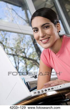 Female university student with a laptop in a classroom View Large Photo Image Stock Photo - Female university student with a laptop in a classroom. Fotosearch
