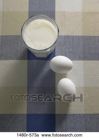 Glass of milk with eggs on a table View Large Photo Image Stock Image - Glass of milk with eggs on a table. Fotosearch