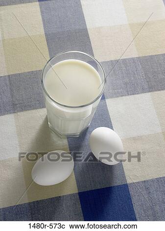 Stock Image - Glass of milk with eggs on a table. Fotosearch
