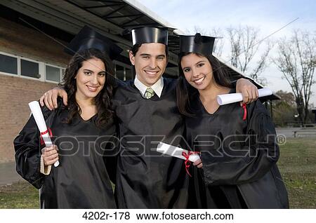 Graduates holding diplomas and smiling View Large Photo Image Stock Photo - Graduates holding diplomas and smiling. Fotosearch