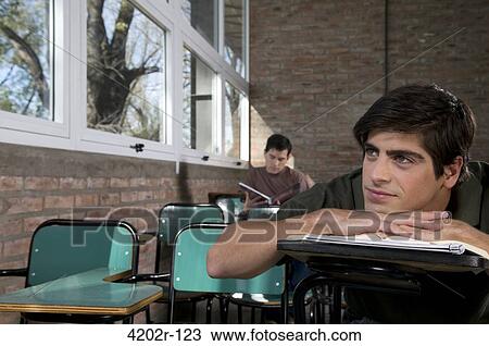 Male university student day dreaming in a classroom View Large Photo Image Stock Image - Male university student day dreaming in a classroom. Fotosearch