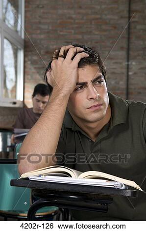Male university student thinking in a classroom View Large Photo Image Stock Photograph - Male university student thinking in a classroom. Fotosearch