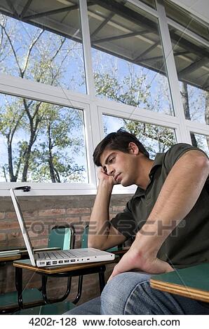 Male university student with a laptop in a classroom View Large Photo Image Stock Photo - Male university student with a laptop in a classroom. Fotosearch