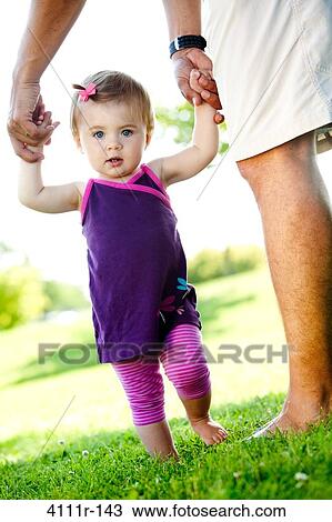 Man helping her daughter to walk, Traverse City, Grand Traverse County, Michigan, USA View Large Photo Image Stock Image - Man helping her daughter to walk, Traverse City, Grand Traverse County, Michigan, USA. Fotosearch