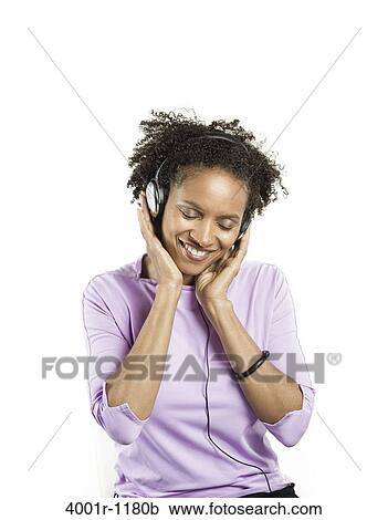 Mid adult woman listening to music with headphones View Large Photo Image Stock Image - Mid adult woman listening to music with headphones. Fotosearch