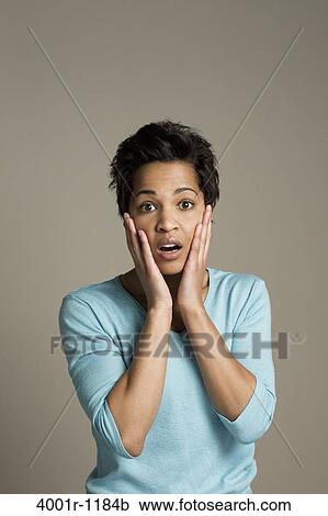 Stock Image - Mid adult woman looking shocked. Fotosearch