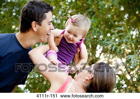 Stock Image - Parents with their daughter in a park, Traverse City, Grand Traverse County, Michigan, USA. Fotosearch