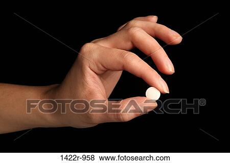Person's hand holding a white pill between the fingers View Large Photo Image Stock Photo - Person's hand holding a white pill between the fingers. Fotosearch