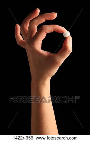 Person's hand holding a white pill between the fingers View Large Photo Image Stock Photograph - Person's hand holding a white pill between the fingers. Fotosearch