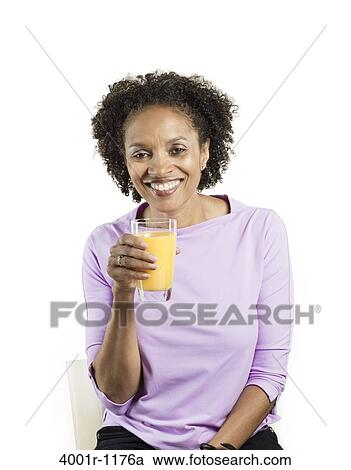 Portrait of a mid adult woman holding a glass of orange juice View Large Photo Image Stock Image - Portrait of a mid adult woman holding a glass of orange juice. Fotosearch