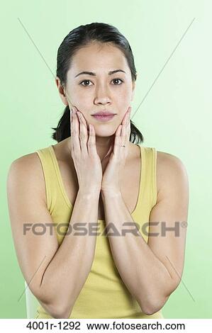 Portrait of a young woman touching her face View Large Photo Image Stock Image - Portrait of a young woman touching her face. Fotosearch