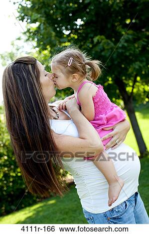 Pregnant woman kissing her daughter View Large Photo Image Stock Photograph - Pregnant woman kissing her daughter. Fotosearch