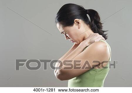 Stock Image - Side profile of a young woman suffering from neckache. Fotosearch
