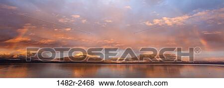 Stock Photo - Sunrise rainbow over the sea, Hood Canal, Seabeck, Kitsap County, Washington State, USA. Fotosearch