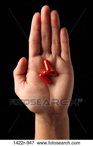 Three red capsules in the palm of a person View Large Photo Image Stock Photo - Three red capsules in the palm of a person. Fotosearch
