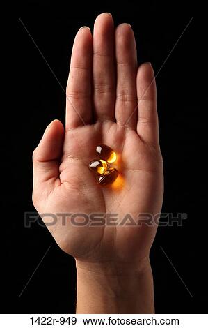 Three small amber capsules in the palm of a person View Large Photo Image Stock Photo - Three small amber capsules in the palm of a person. Fotosearch