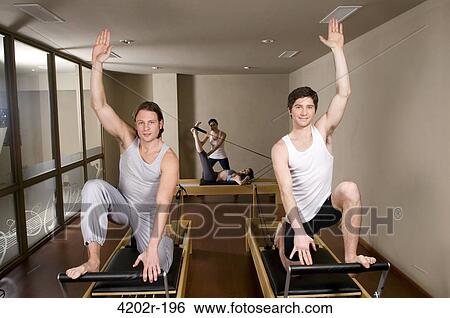 Two young men exercising in a gym View Large Photo Image Stock Photograph - Two young men exercising in a gym. Fotosearch