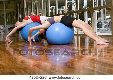 Stock Photograph - Two young women exercising on fitness balls. Fotosearch