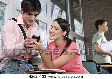 University students text messaging with a mobile phone in a classroom View Large Photo Image Stock Image - University students text messaging with a mobile phone in a classroom. Fotosearch