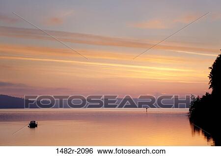 Stock Photograph - USA, Washington State, Hood Canal, boat on sunrise. Fotosearch