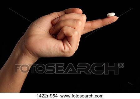 White pill at the fingertip of a person View Large Photo Image Picture - White pill at the fingertip of a person. Fotosearch