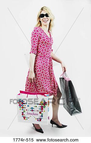 Woman carrying shopping bags and smiling View Large Photo Image Stock Photography - Woman carrying shopping bags and smiling. Fotosearch