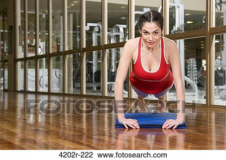 Woman doing push-ups in a gym View Large Photo Image Stock Image - Woman doing push-ups in a gym. Fotosearch