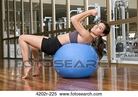 Woman exercising on a fitness ball View Large Photo Image Stock Photography - Woman exercising on a fitness ball. Fotosearch