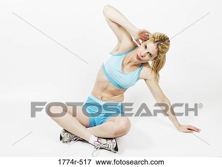 Woman sitting on the floor and exercising View Large Photo Image Stock Photo - Woman sitting on the floor and exercising. Fotosearch
