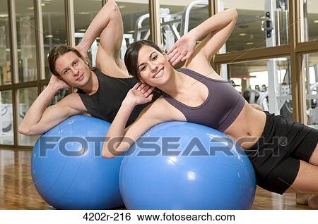Young couple exercising on fitness balls View Large Photo Image Stock Photograph - Young couple exercising on fitness balls. Fotosearch