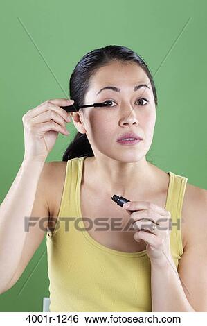 Young woman applying mascara View Large Photo Image Stock Photograph - Young woman applying mascara. Fotosearch