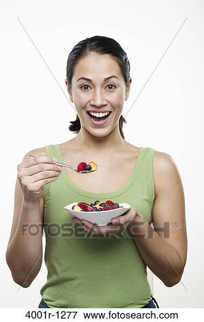 Young woman eating fruit salad and smiling View Large Photo Image Stock Photo - Young woman eating fruit salad and smiling. Fotosearch