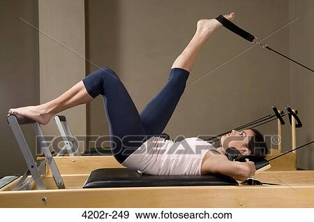 Young woman exercising in a gym View Large Photo Image Stock Photo - Young woman exercising in a gym. Fotosearch