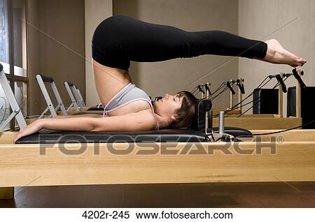 Young woman exercising in a gym View Large Photo Image Stock Photography - Young woman exercising in a gym. Fotosearch